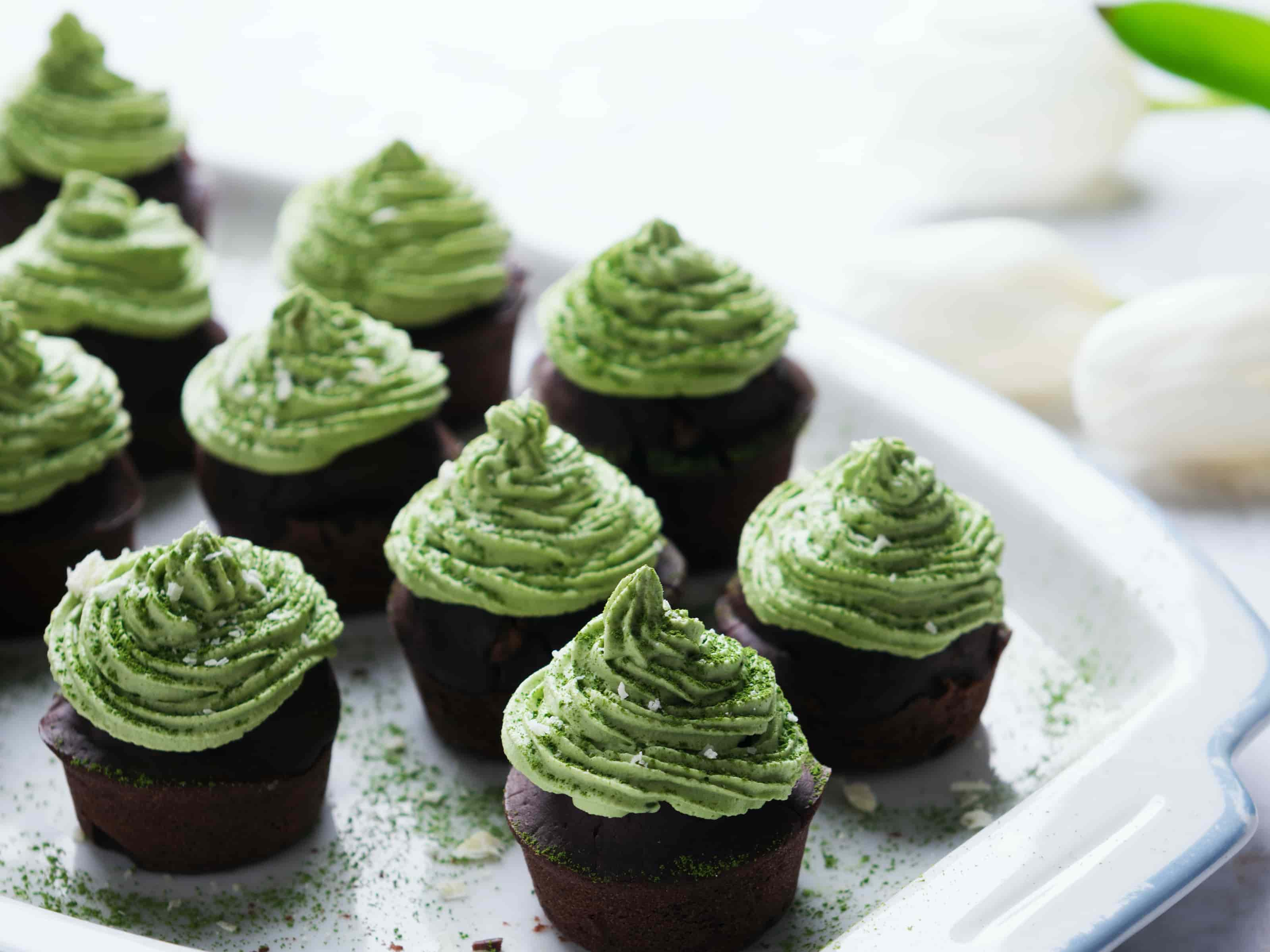 Schokoladenbraune Cupcakes mit gruener Buttercreme Haube mit Matcha