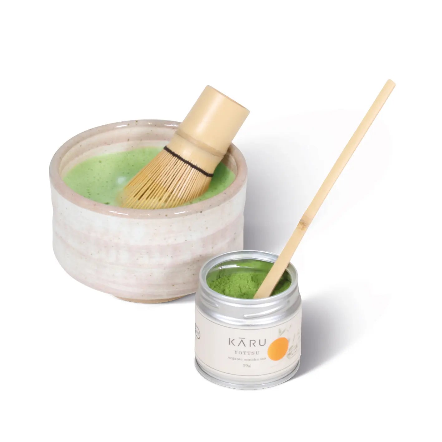 Eine Schüssel Bio Matcha Set Yottsu mit einem Holzlöffel und einem Bambusbesen von Matcha Kāru.