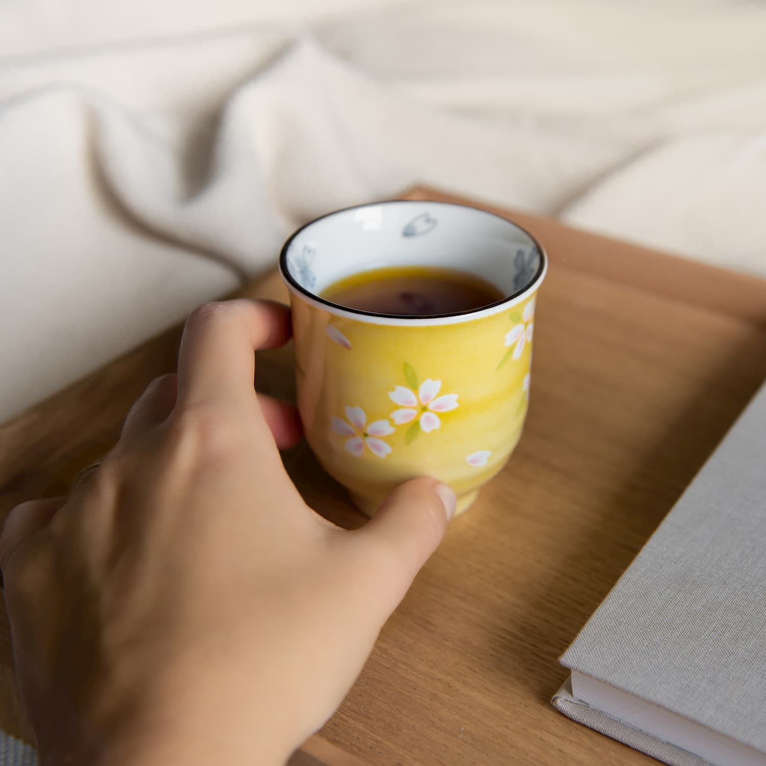 Tee Tasse mit Blumen und Hand daneben